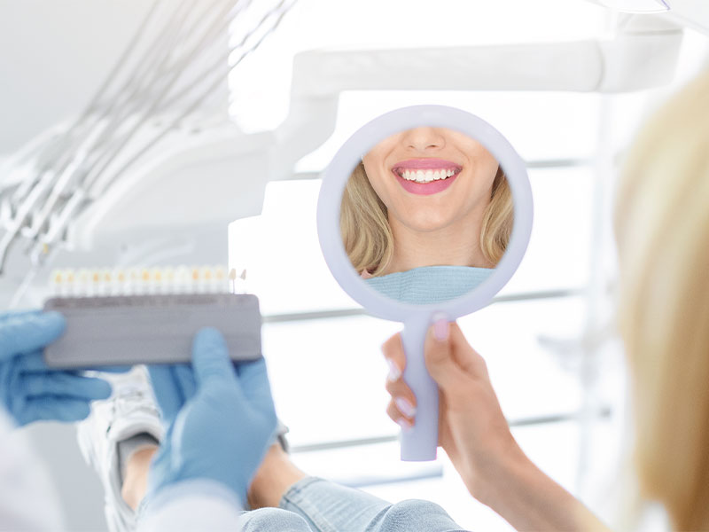 a woman smiling and showing her crowns